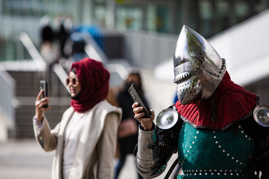 People in costume check their cellphones