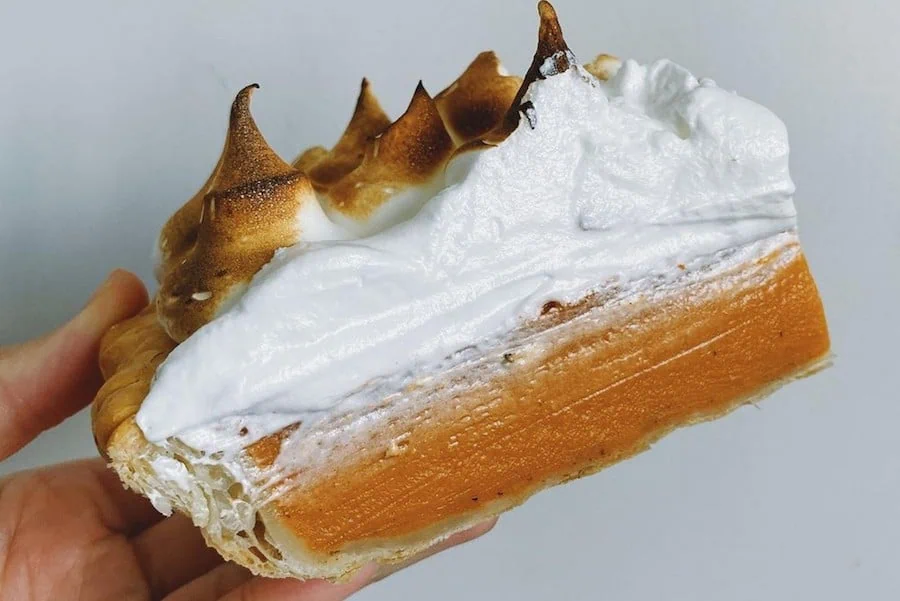 A hand holding a piece of pie