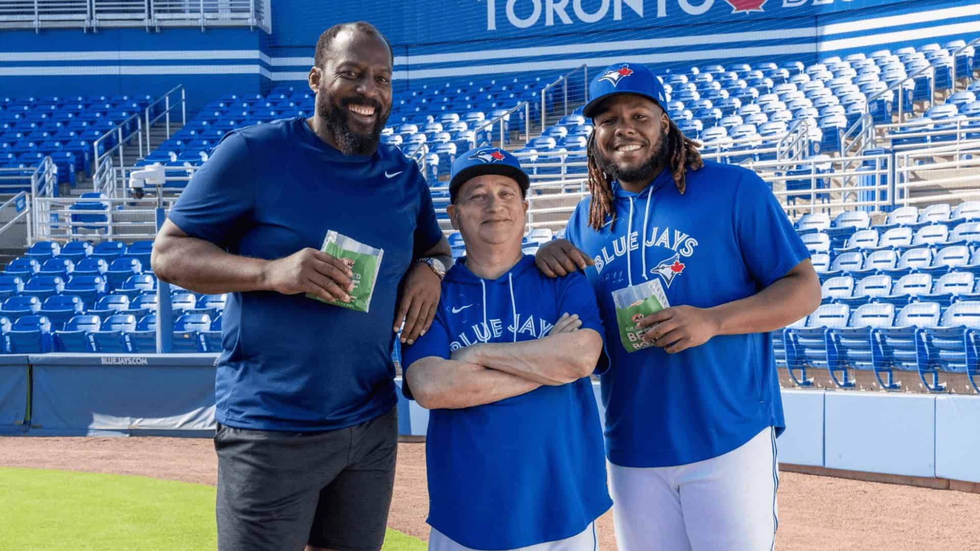 Smiling group of diverse men in Blue Jays apparel at Rogers Centre in Toronto, enjoying a baseball game.