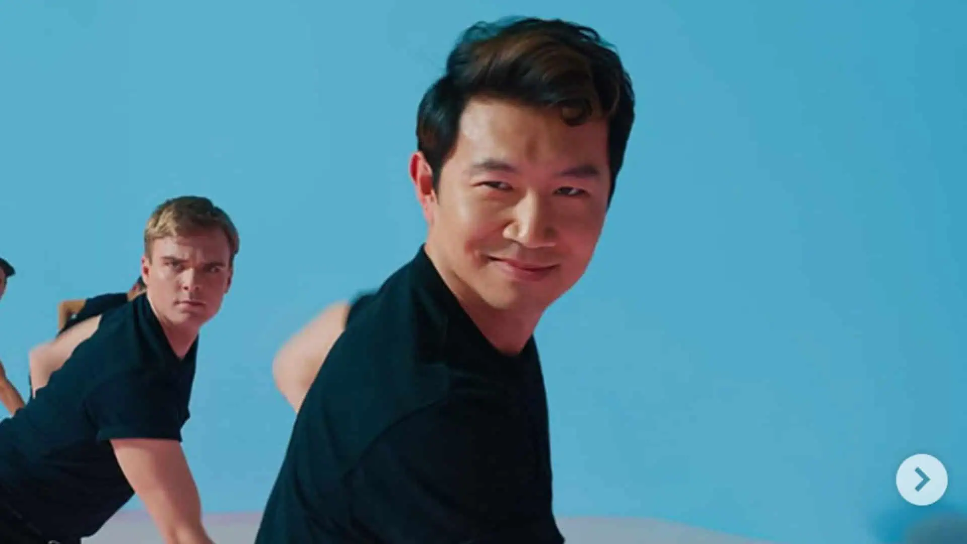 Cheerful Asian man with friends enjoying outdoor activity on a bright sunny day.