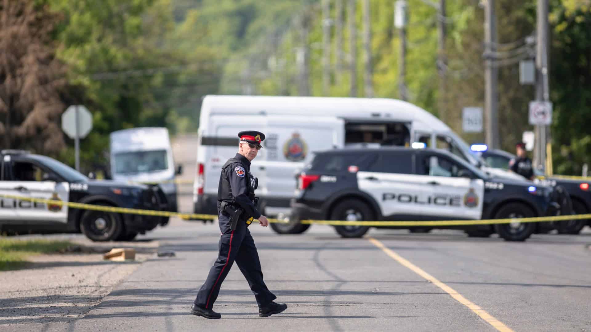 Emergency police scene on Toronto street with police cars and officers securing the area.