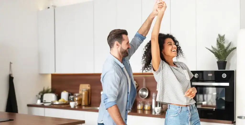 Happy couple celebrating in modern kitchen, joyful moment, love, happiness, home life, relationship, enjoying time together, Toronto lifestyle.