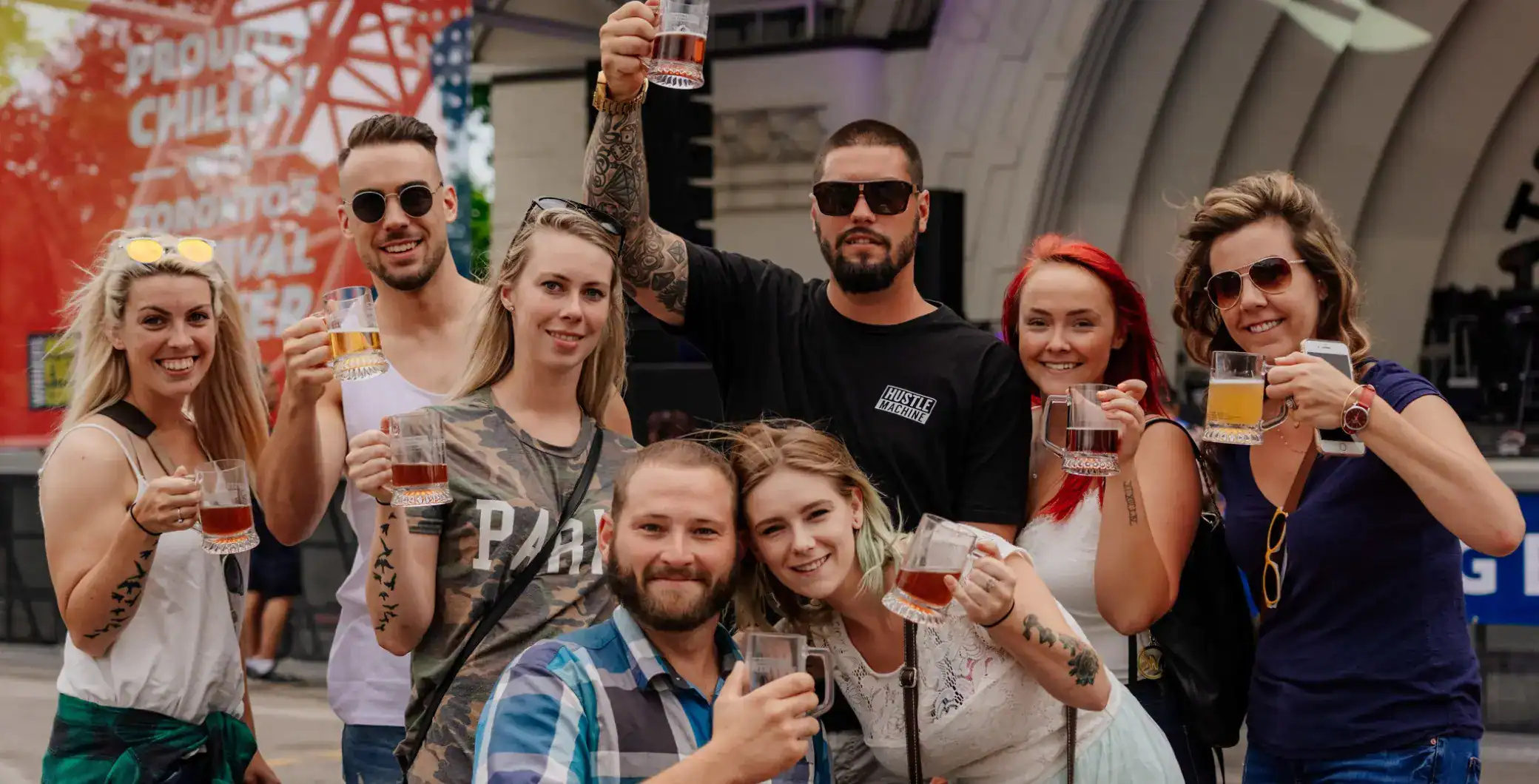Vibrant group of friends celebrating outdoors in Toronto with drinks, smiling, and enjoying summer events, showcasing Toronto nightlife and social scene.