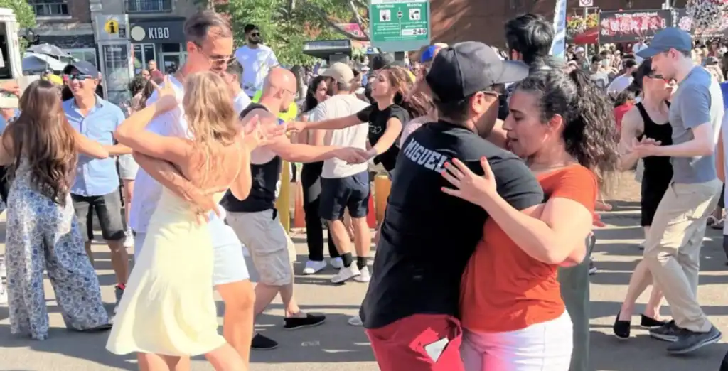 Vibrant outdoor dance event in Toronto featuring diverse crowd enjoying music and dancing on sunny day.