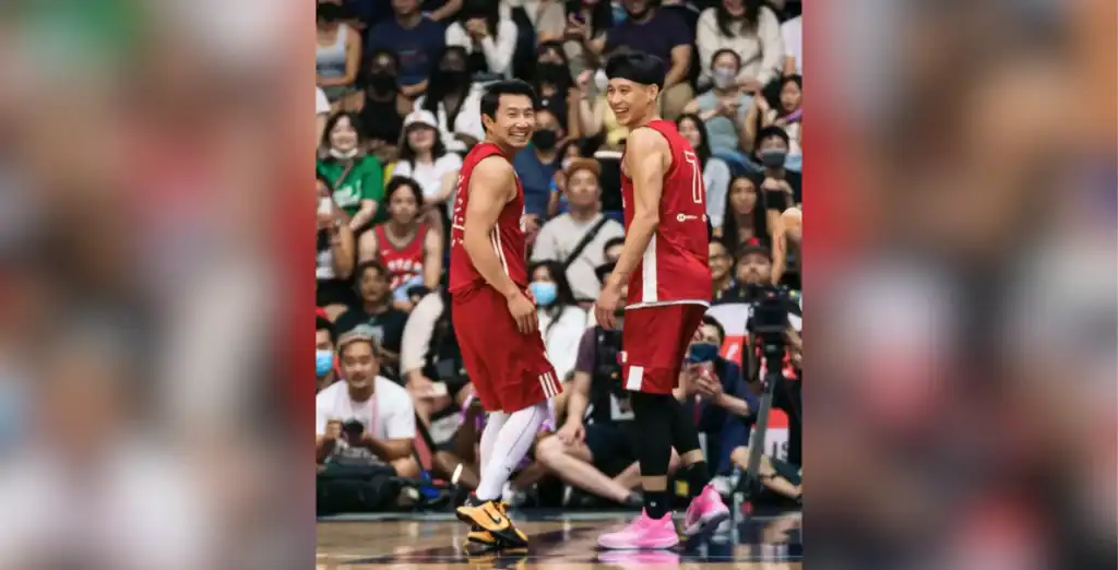Two basketball players celebrating during a game with a large, cheering crowd in the background at a Toronto sports event.