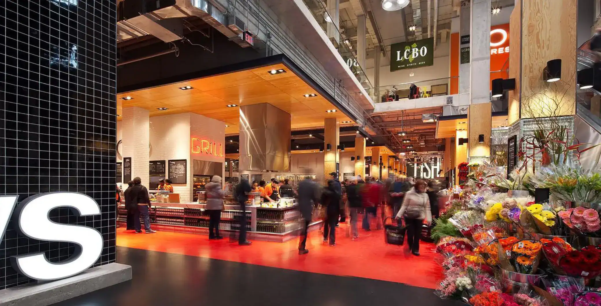 Vibrant indoor market in Toronto featuring fresh flowers, buzzing food stalls, and modern design, capturing the lively atmosphere of NOW Toronto.