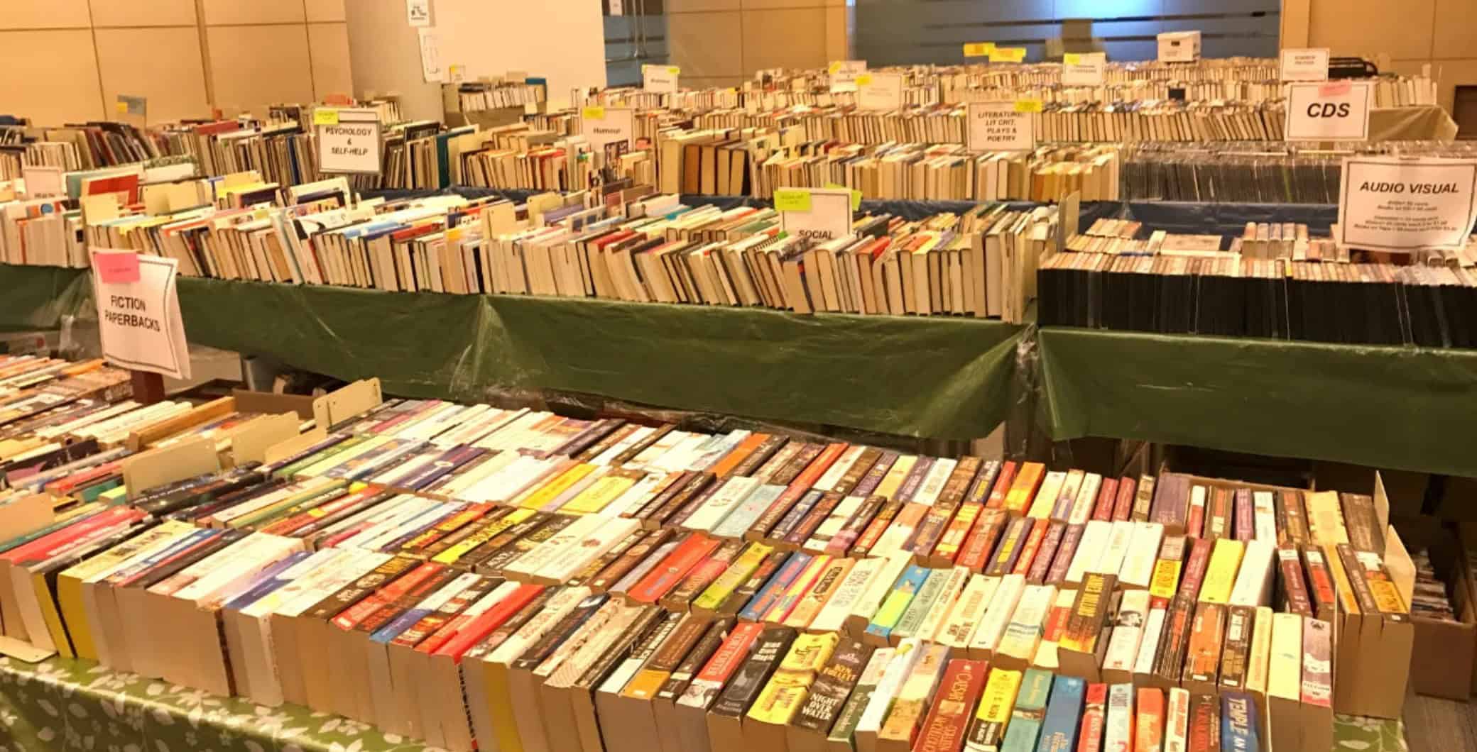 Colorful books stacked on tables at a Toronto bookstore or book fair.