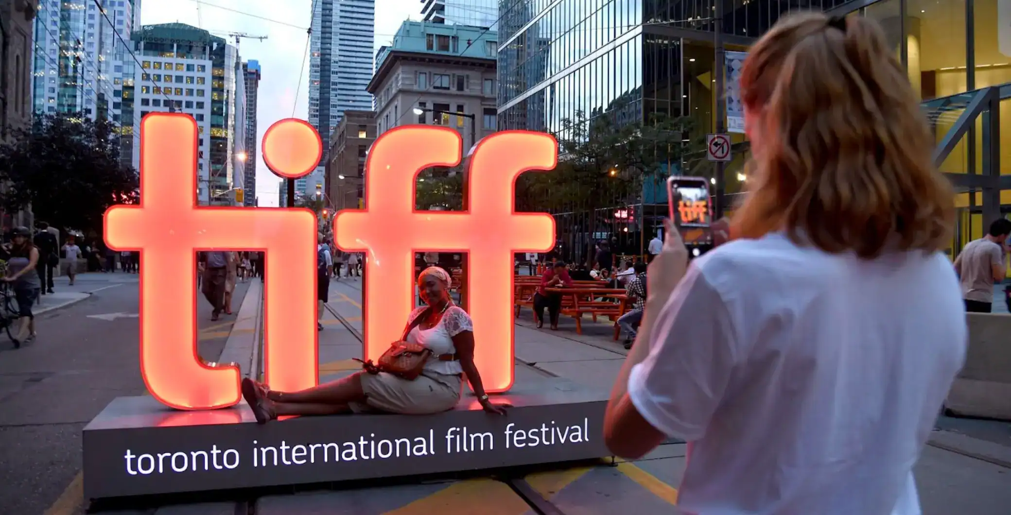 Bright Toronto International Film Festival sign illuminated at an outdoor event in downtown Toronto during evening.