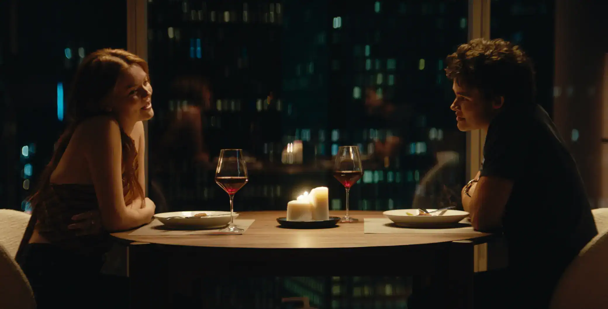 Romantic dinner for two with wine glasses and candlelight overlooking Toronto skyline, cozy ambiance, and evening city lights in a high-rise restaurant setting.