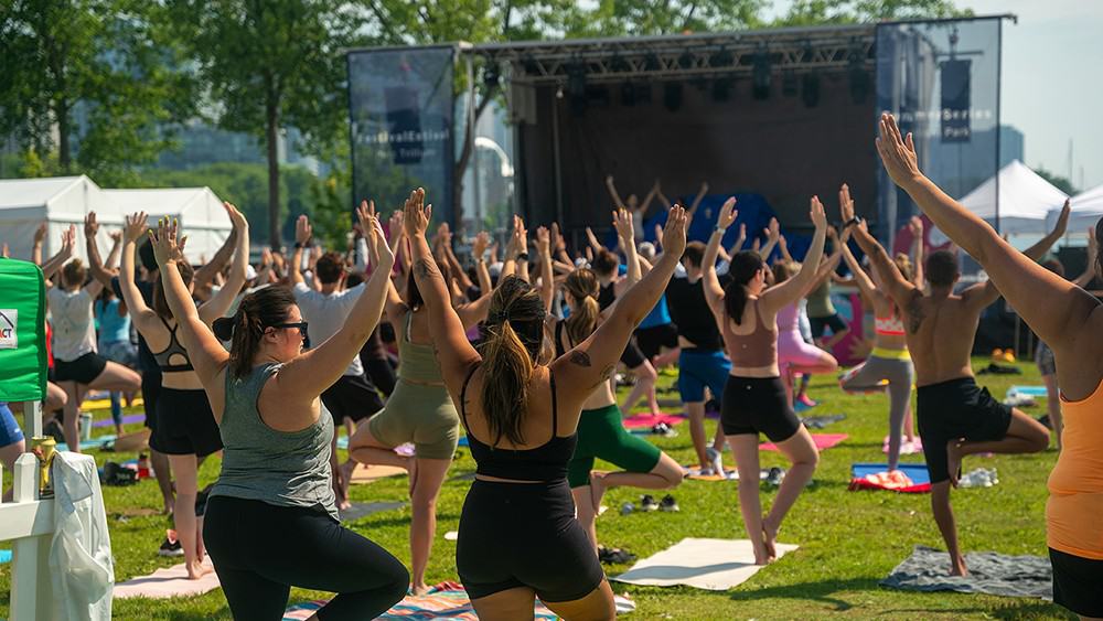 People doing outdoor yoga in Toronto park, healthy lifestyle, fitness class, wellness activity, community exercise, event in Toronto, NOW Toronto.