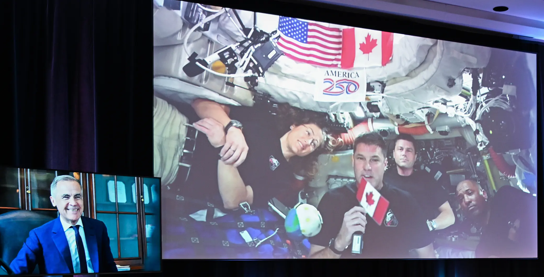 An astronaut holding a Canadian flag inside the spacecraft, with other crew members and space equipment visible.