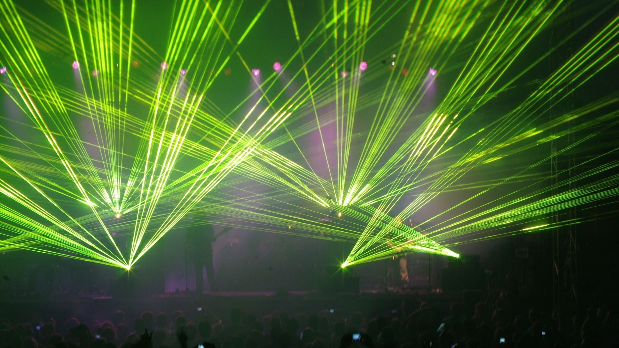 Dynamic green laser light display at a live music event, showcasing colorful beams and energetic atmosphere, ideal for concert and entertainment-related content.