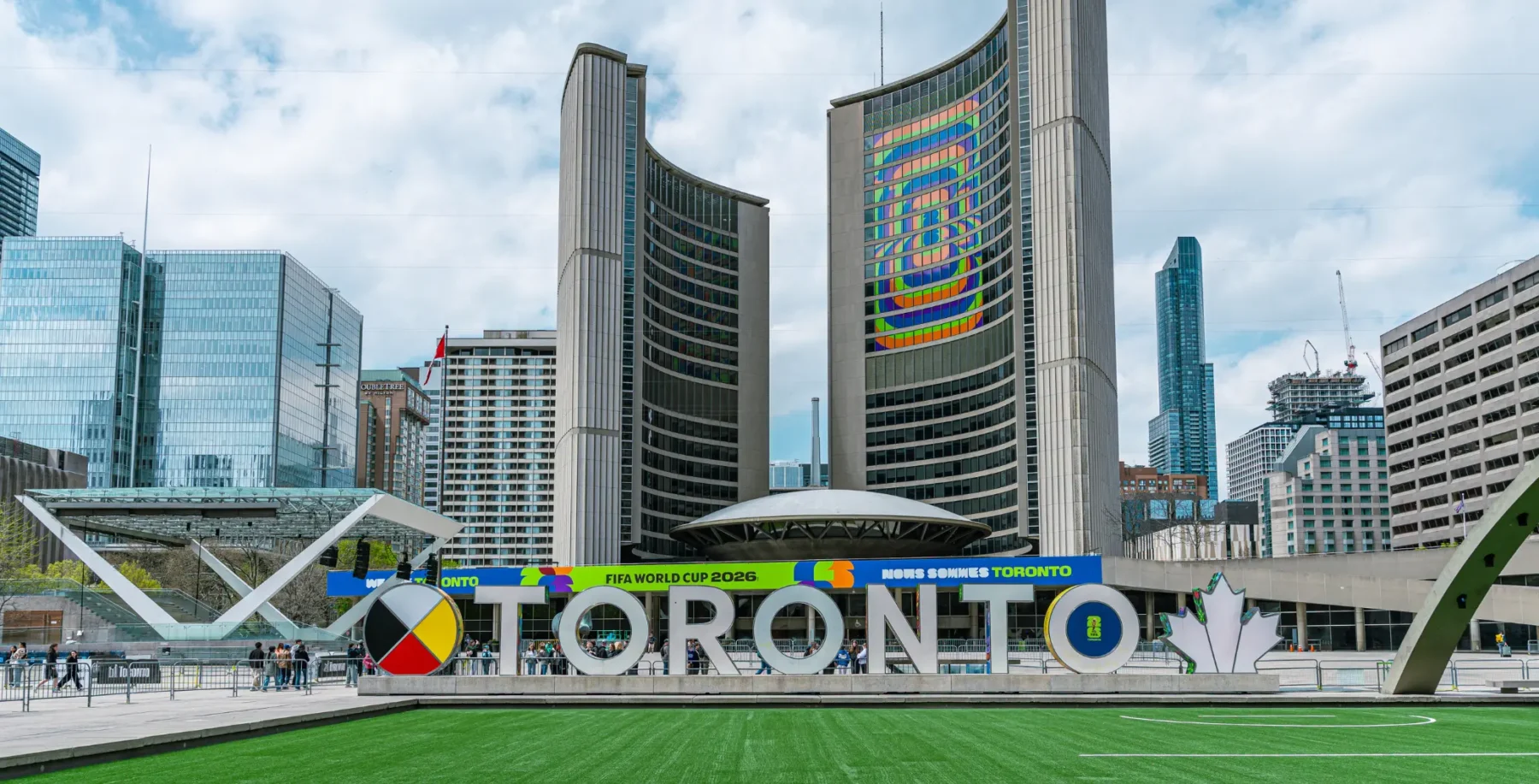 Toronto City Hall and downtown Toronto skyline with prominent "TORONTO" sign, modern architecture, and urban landscape in Canada.