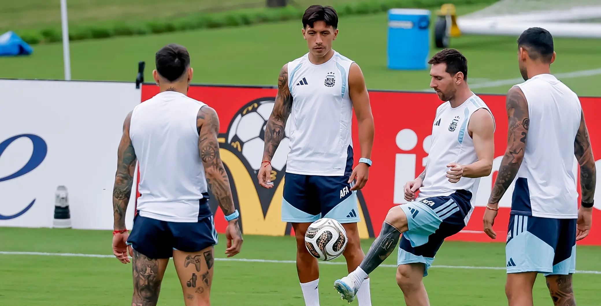 Argentina national football team training session on a green field with players in white and blue jerseys.