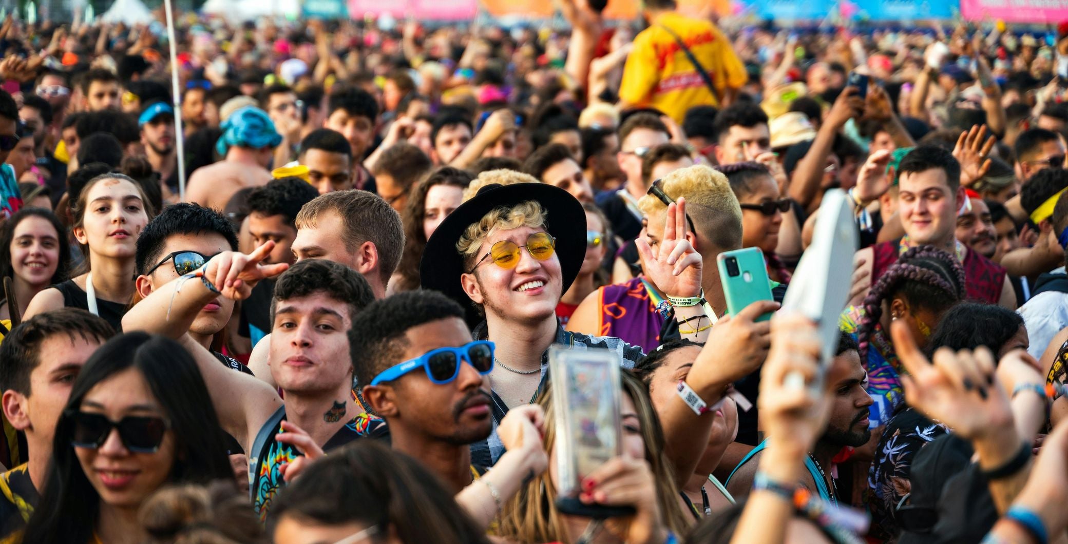 Crowd of diverse festivalgoers enjoying music and dancing at a lively outdoor event in Toronto.