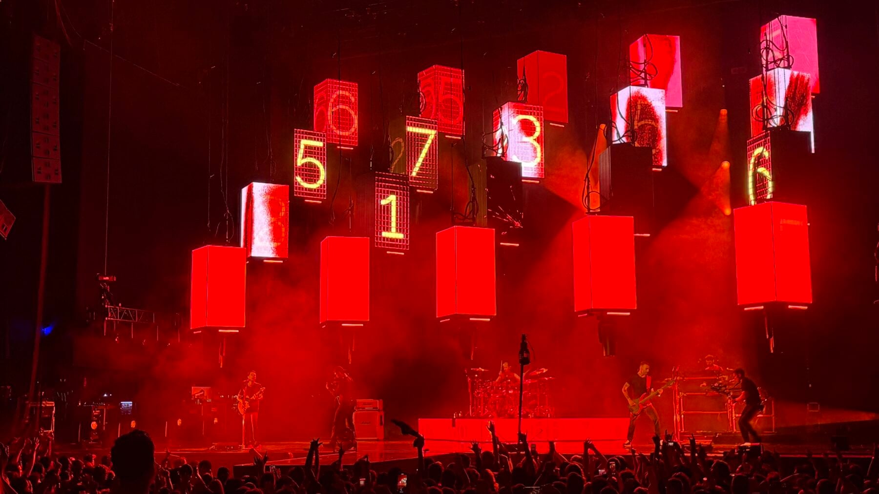 Stage with red lighting and large digital countdown screens displaying numbers 5, 7, 1, 3, 6, 4, 2, 8, 9, 0 at NOW Toronto event.