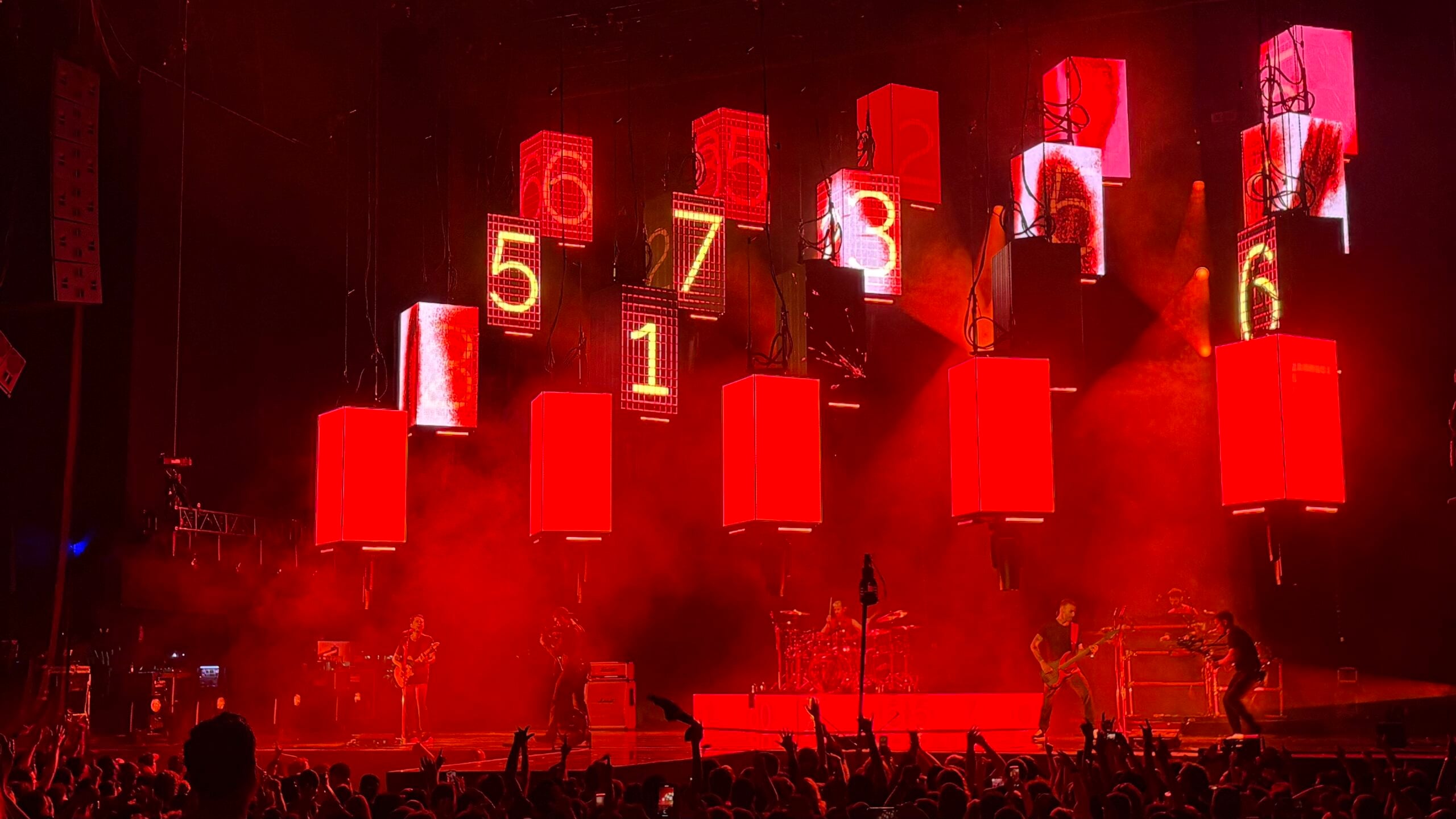 Stage with red lighting and large digital countdown screens displaying numbers 5, 7, 1, 3, 6, 4, 2, 8, 9, 0 at NOW Toronto event.