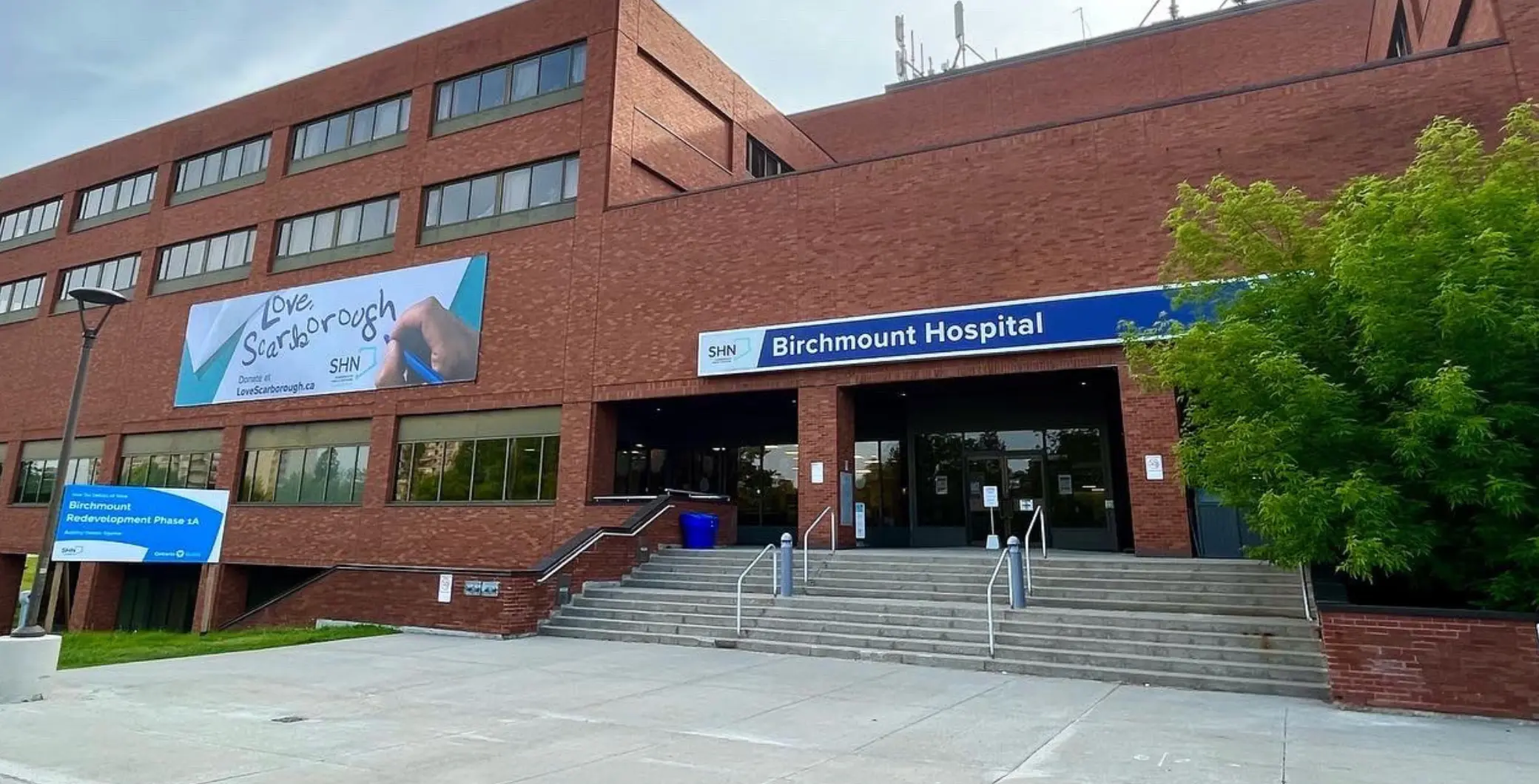 Birchmount Hospital entrance with steps, signage, and surrounding greenery in Toronto, Ontario.