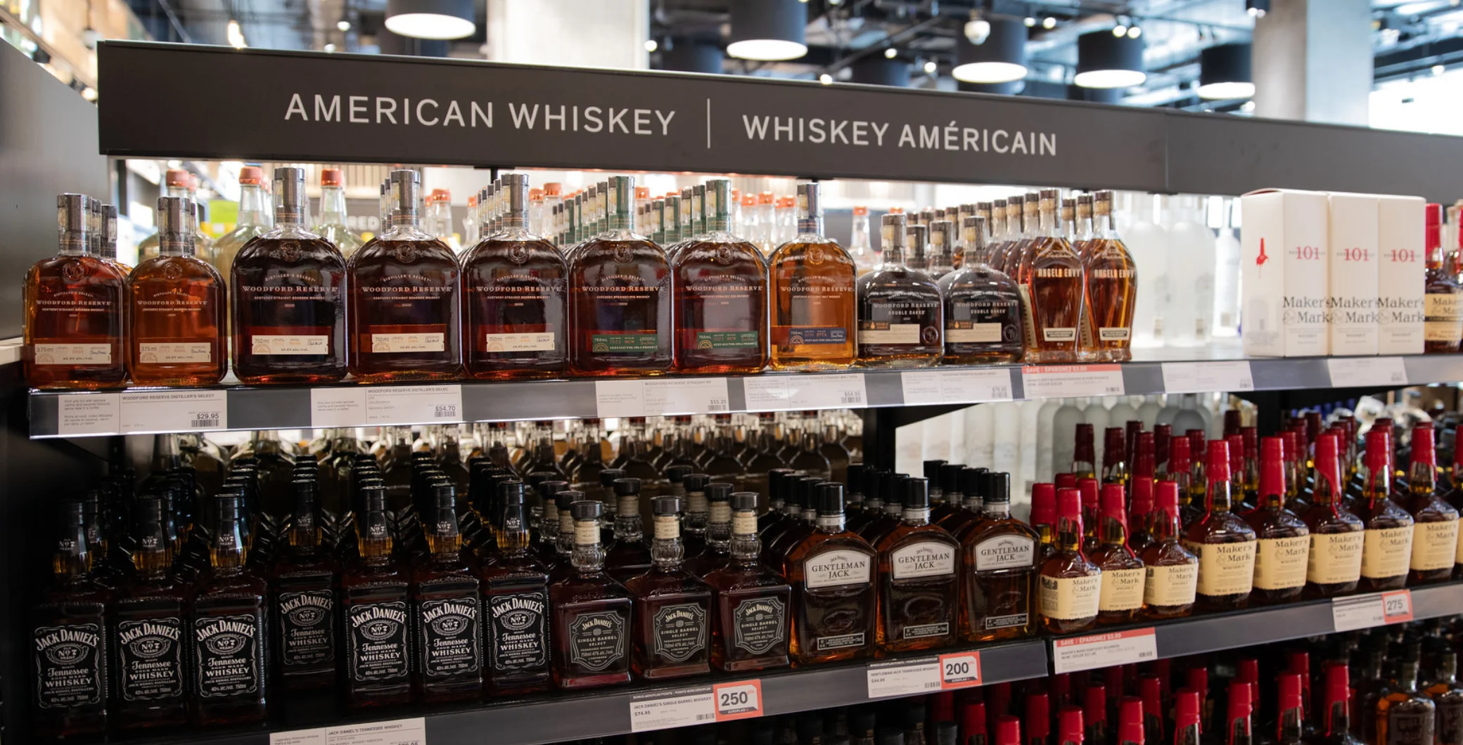 Selection of American whiskey bottles on store shelf at NOW Toronto, showcasing popular spirits for consumers.
