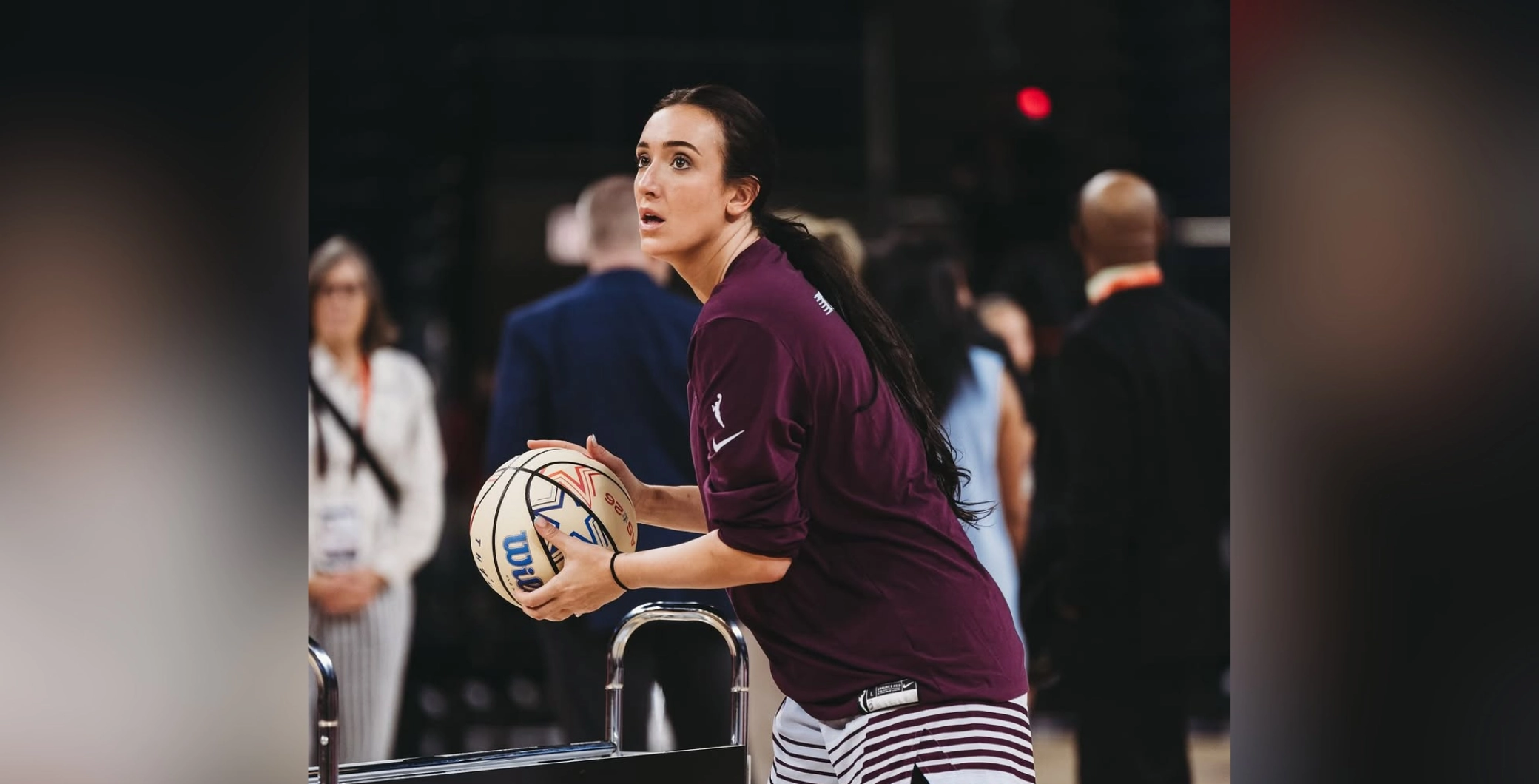 Marina Mabrey preparing to shoot a basketball during a Toronto event, surrounded by spectators and officials.